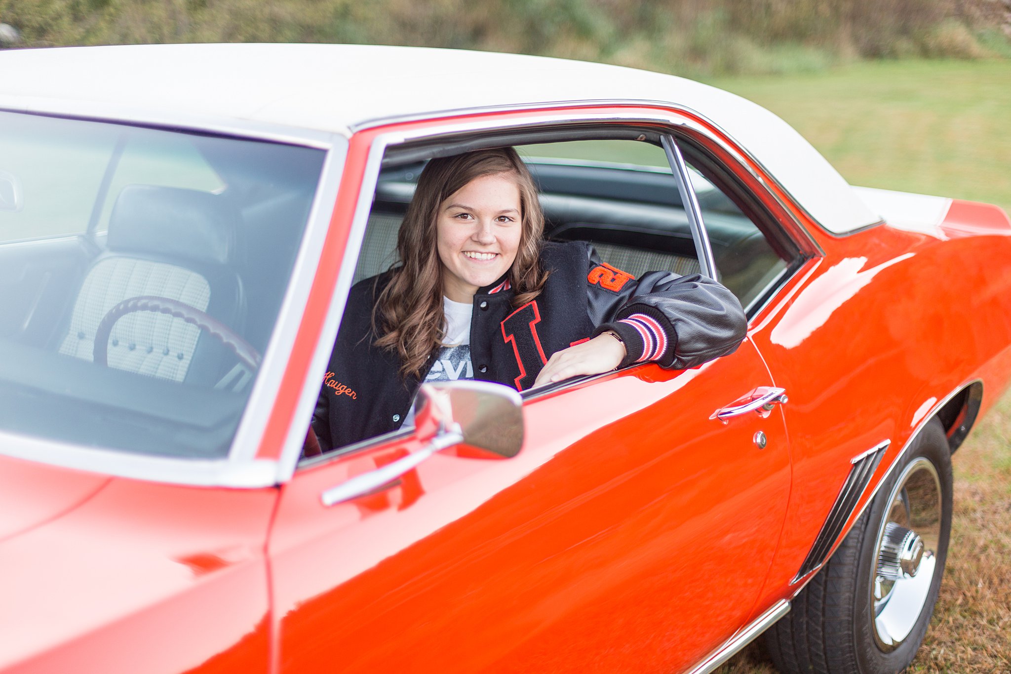 girl sits in a classic muscle car wearing a letterman jacket mayo senior high school